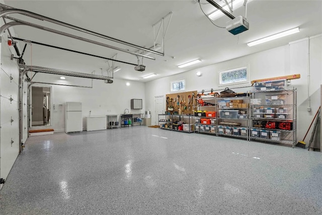 garage with a garage door opener and freestanding refrigerator