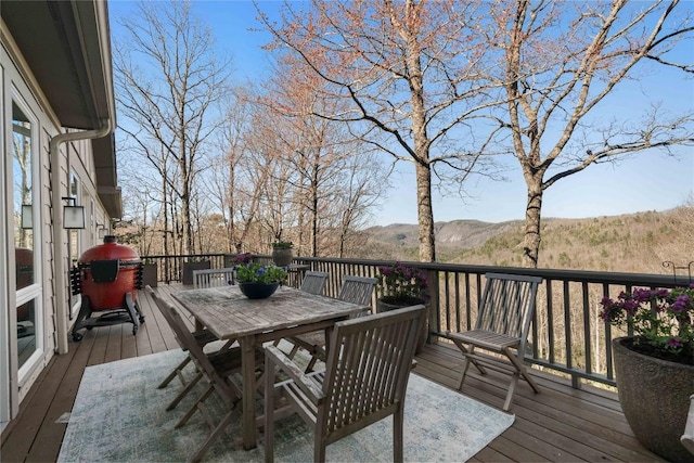 wooden terrace featuring a mountain view and outdoor dining space