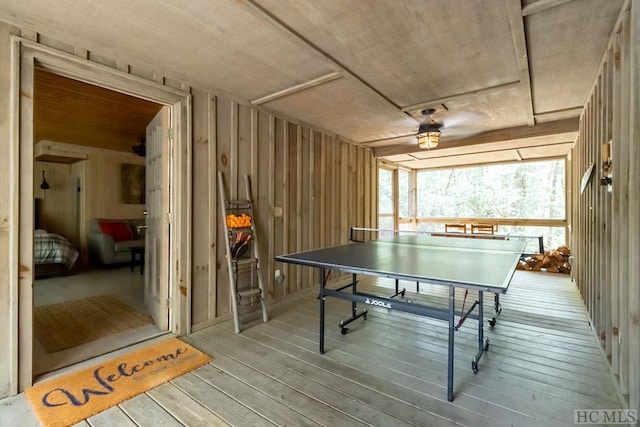 recreation room featuring wood walls and wood-type flooring