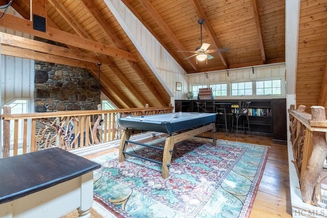 recreation room with wood ceiling, wood walls, vaulted ceiling with beams, ceiling fan, and wood-type flooring