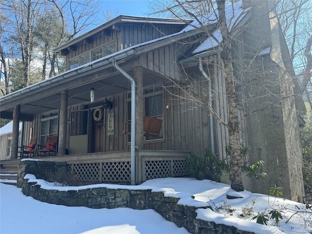 view of snowy exterior featuring a porch