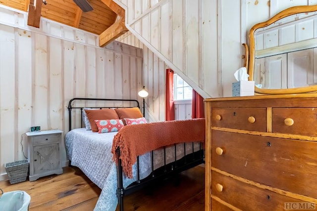 bedroom featuring wood walls and hardwood / wood-style floors