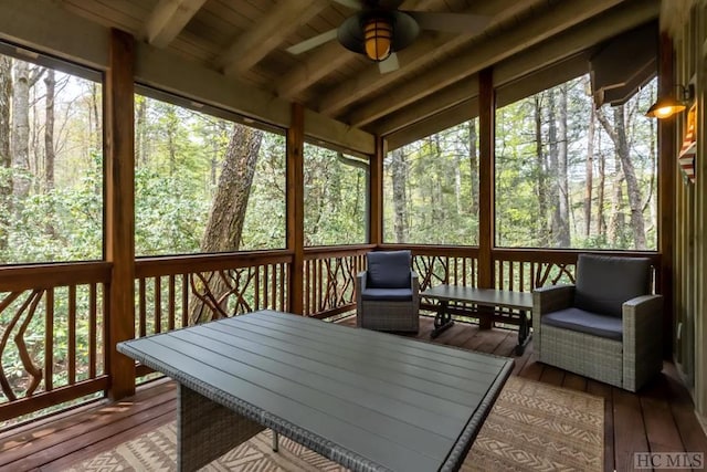 sunroom / solarium featuring ceiling fan, wood ceiling, vaulted ceiling with beams, and a healthy amount of sunlight