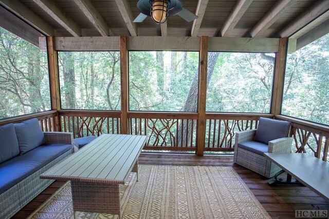 sunroom featuring beamed ceiling and ceiling fan