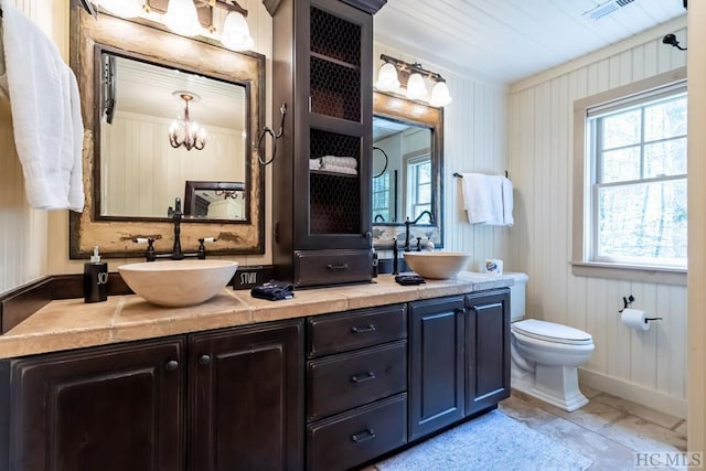 bathroom with toilet, vanity, and an inviting chandelier