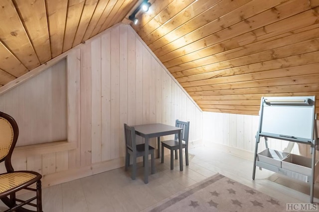 additional living space featuring lofted ceiling, wood ceiling, and wooden walls