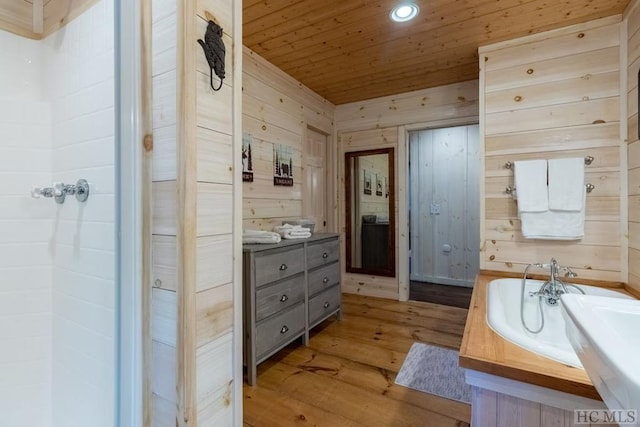 bathroom featuring wood-type flooring, wood ceiling, wood walls, and a tub to relax in