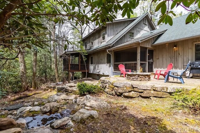 back of house featuring a patio, an outdoor fire pit, and a sunroom