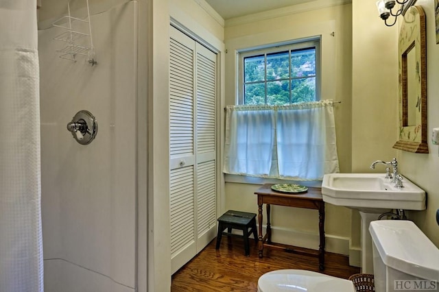 bathroom featuring hardwood / wood-style flooring, ornamental molding, curtained shower, and toilet