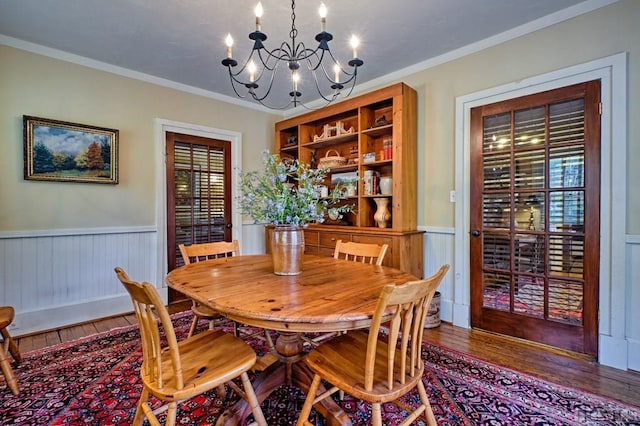 dining room featuring an inviting chandelier, crown molding, and hardwood / wood-style flooring