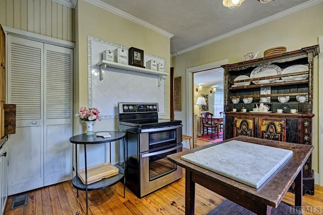 kitchen with double oven range, crown molding, and light hardwood / wood-style floors