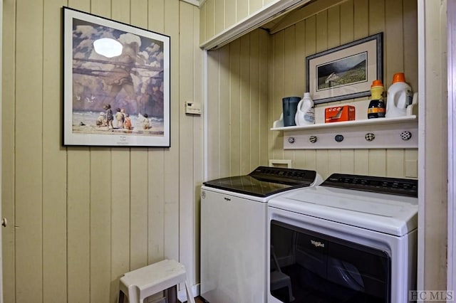 laundry area featuring independent washer and dryer and wood walls