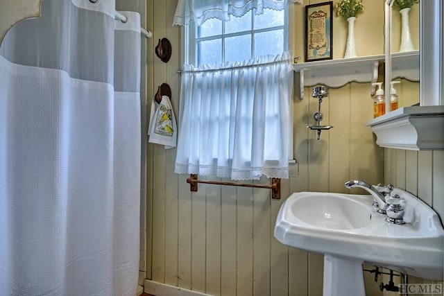 bathroom with sink and wood walls