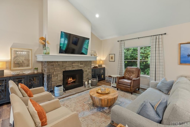 living room featuring a stone fireplace, hardwood / wood-style floors, and lofted ceiling