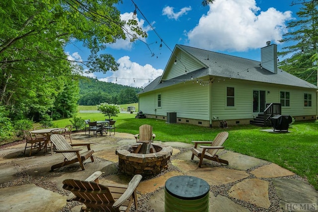 back of property featuring central AC, a patio, a fire pit, and a lawn