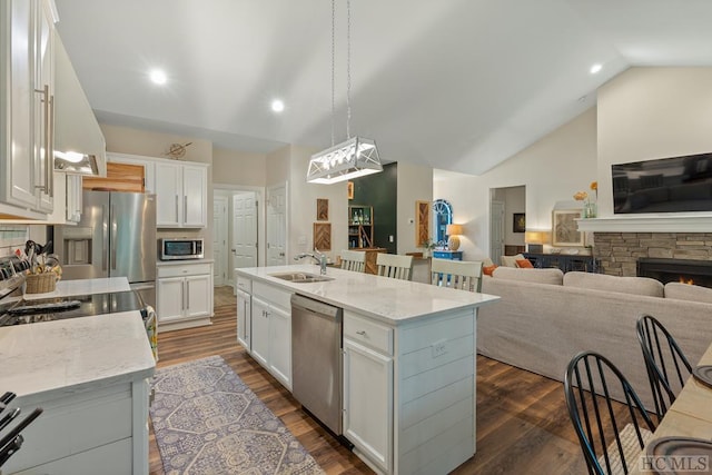 kitchen featuring white cabinetry, stainless steel appliances, a kitchen island with sink, and pendant lighting