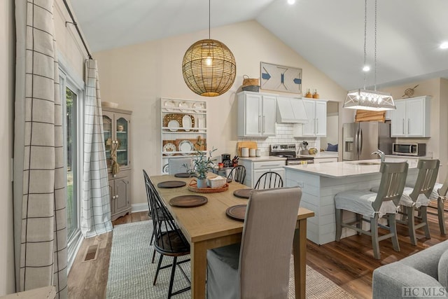 dining space with lofted ceiling and dark hardwood / wood-style floors