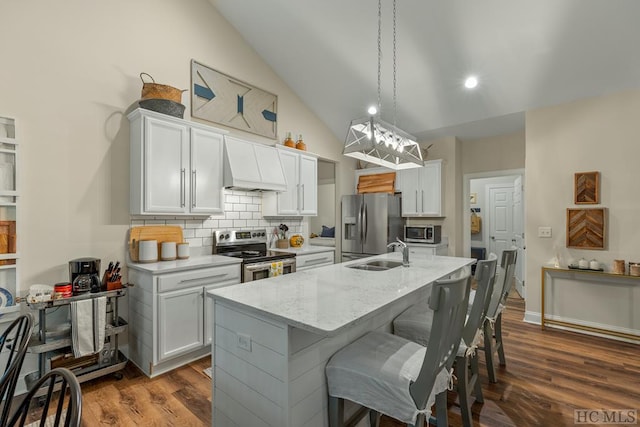 kitchen with premium range hood, sink, white cabinetry, hanging light fixtures, and appliances with stainless steel finishes