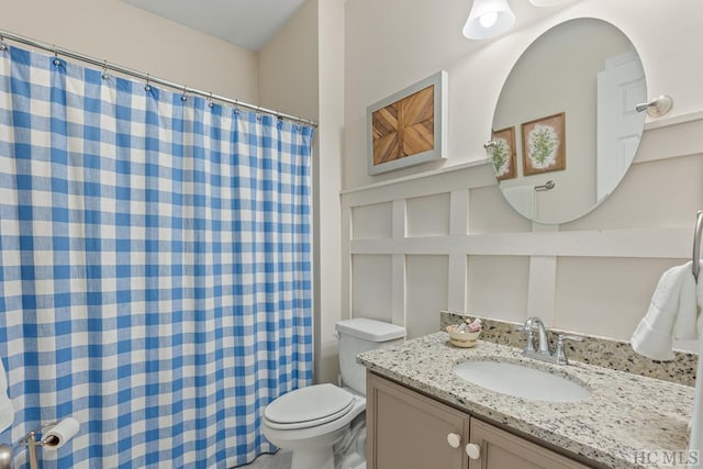 bathroom with vanity, a shower with shower curtain, and toilet