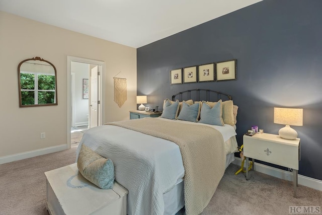 carpeted bedroom featuring ensuite bath