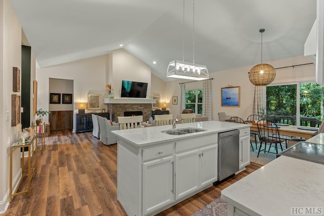 kitchen with sink, dishwasher, white cabinetry, hanging light fixtures, and a center island with sink