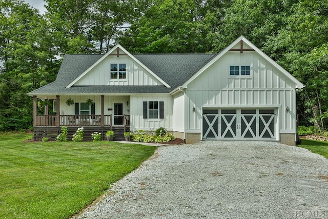 view of front of home featuring a porch, a garage, and a front yard