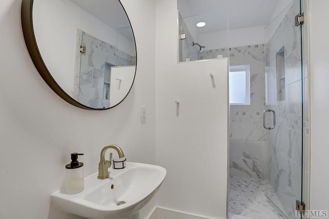 bathroom with sink and a shower with door