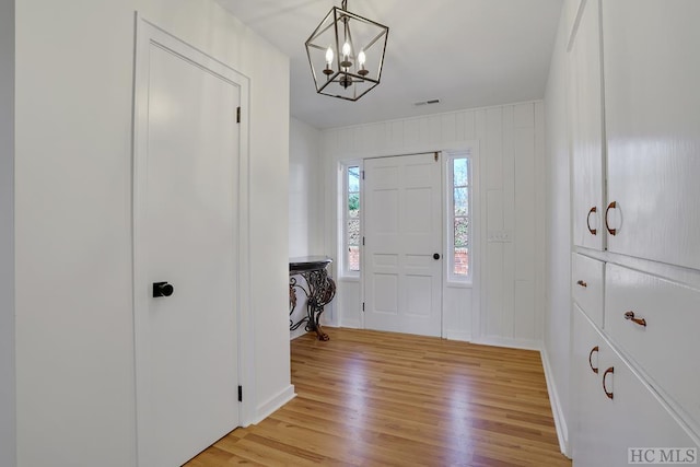 foyer entrance featuring an inviting chandelier and light hardwood / wood-style floors