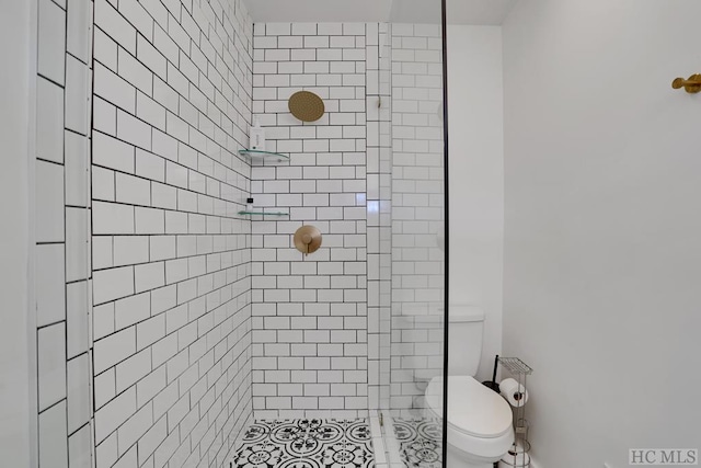 bathroom with toilet and tiled shower