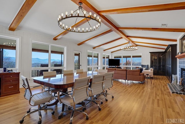 dining space with light hardwood / wood-style flooring, plenty of natural light, an inviting chandelier, and vaulted ceiling with beams