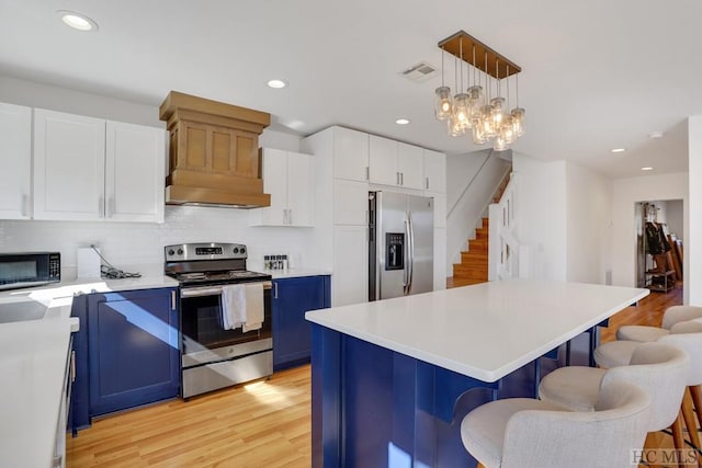 kitchen featuring blue cabinetry, white cabinetry, pendant lighting, a kitchen island, and stainless steel appliances