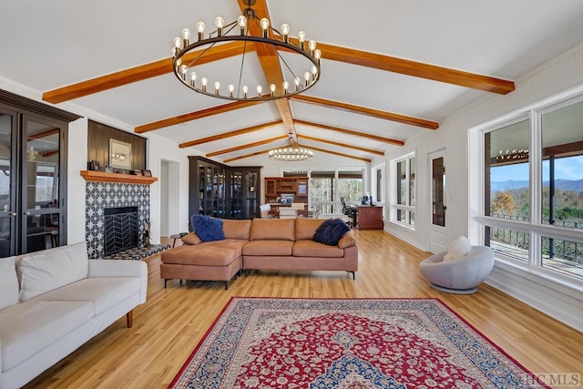 living room featuring light wood-type flooring, a chandelier, and vaulted ceiling with beams