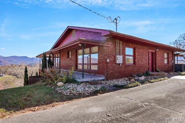 view of home's exterior with central AC unit and a mountain view