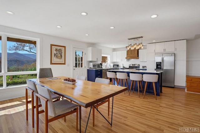 dining space featuring sink, a mountain view, and light hardwood / wood-style floors