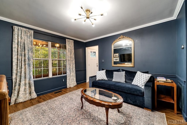 living room with dark hardwood / wood-style flooring, a notable chandelier, and crown molding