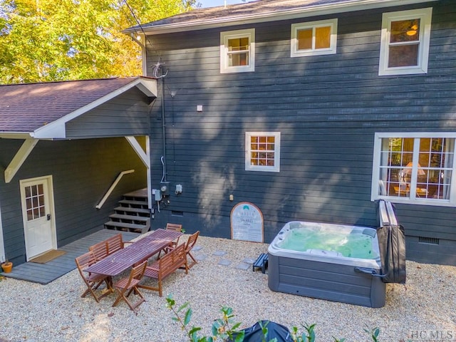 back of property featuring a hot tub and a patio