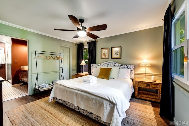 bedroom with crown molding, dark wood-type flooring, and ceiling fan