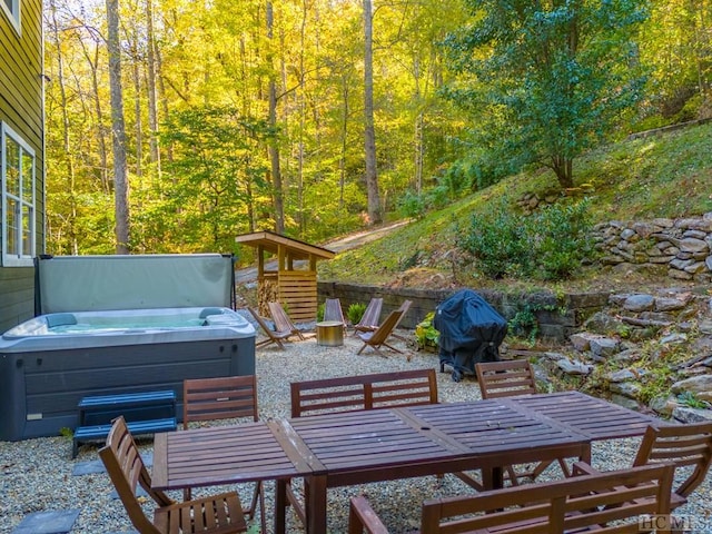 wooden deck featuring a hot tub, area for grilling, and a patio area