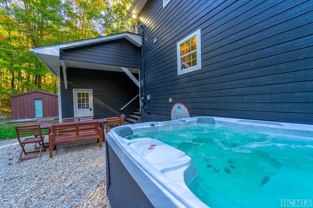 view of patio with a hot tub and a storage unit