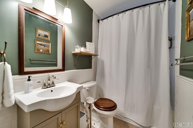 bathroom featuring a shower with curtain, vanity, toilet, and tile walls