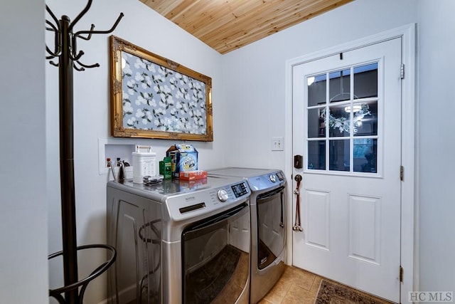 clothes washing area featuring washer and dryer, light tile patterned floors, and wooden ceiling