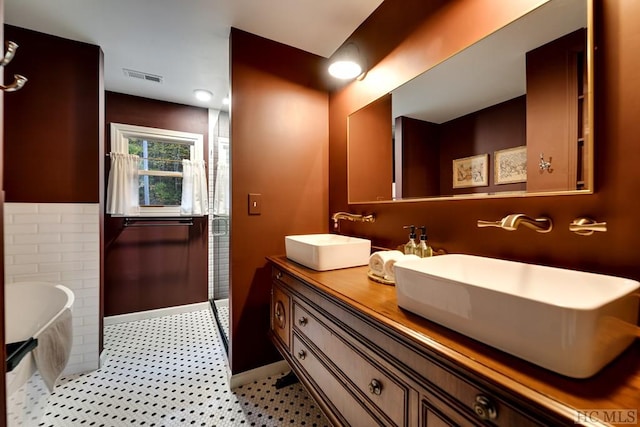 bathroom featuring tile patterned flooring, vanity, and a bathtub