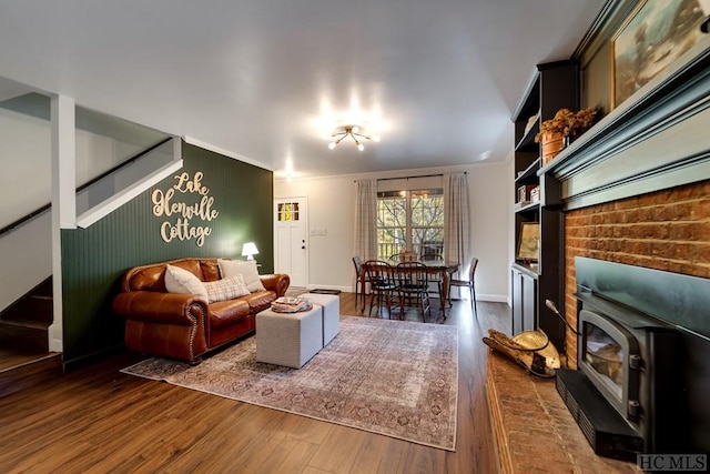 living room with dark wood-type flooring, a wood stove, and crown molding