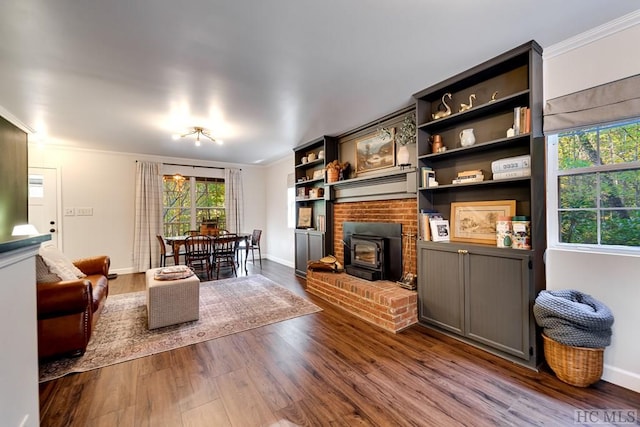 living room with hardwood / wood-style floors, crown molding, and a wood stove