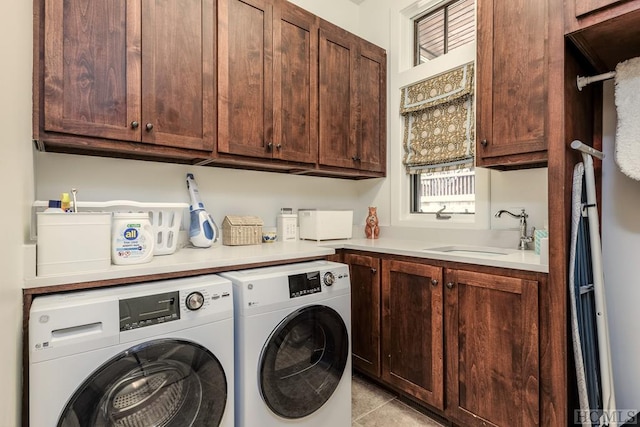 washroom with sink, light tile patterned floors, cabinets, and washing machine and clothes dryer