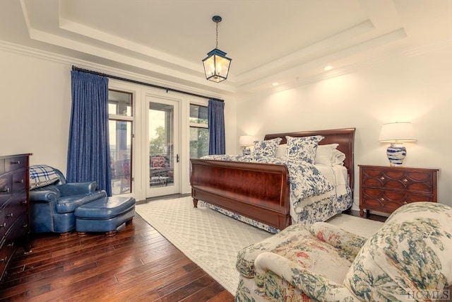 bedroom featuring a raised ceiling, crown molding, hardwood / wood-style flooring, and access to outside