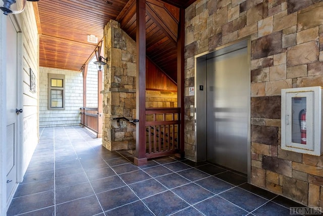 hallway featuring lofted ceiling, wooden ceiling, and elevator