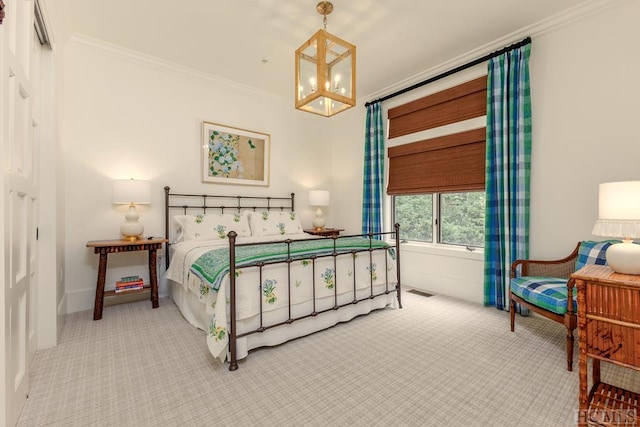 bedroom with a notable chandelier, crown molding, and carpet flooring