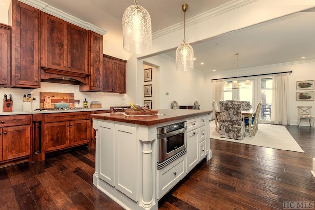 kitchen with stainless steel appliances, dark hardwood / wood-style floors, tasteful backsplash, a kitchen island, and decorative light fixtures