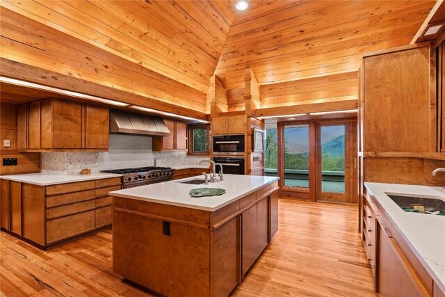 749 Stillmont Cir, Cashiers, NC 28717 - kitchen with wall chimney range hood, brown cabinets, light countertops, and tasteful backsplash